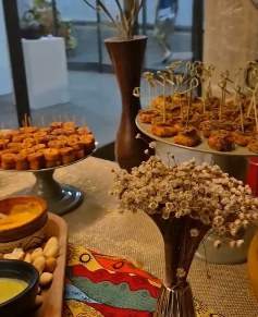 Mesa de evento com finger foods e arranjo de flores secas